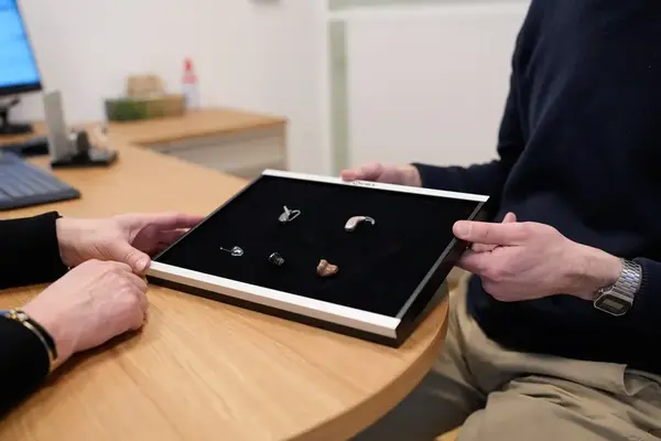 Verschiedene Hörgeräte werden bei einer Beratung im Hörakustiker-Fachgeschäft präsentiert.